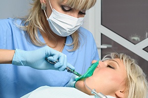 Dentist removing woman’s teeth using pulling method