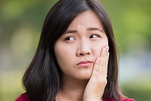 Woman holding jaw in pain