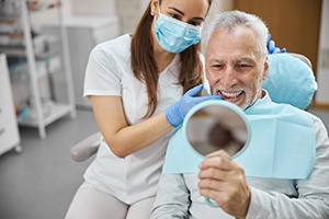 man admiring his new dental crown in Rockville