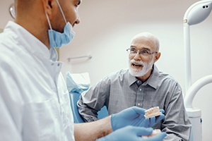 dentist explaining the cost of dental implants to an older patient