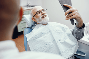 a patient smiling after restoring their missing teeth