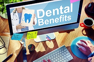 Checking dental benefits on computer on busy desktop