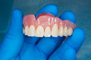 lab tech holding dentures in Rockville 