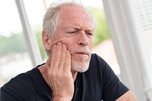 Older man with dental pain needs tooth extraction
