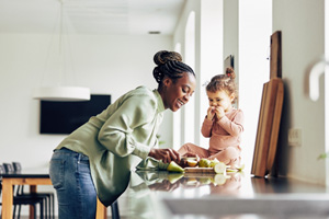 Mother and daughter eating snack in kitchen