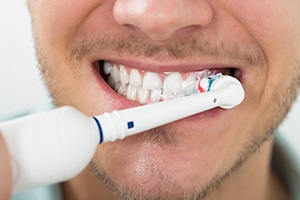 Man brushing teeth with a manual toothbrush