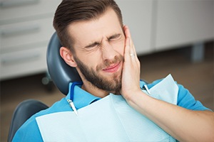 Man holding jaw in pain