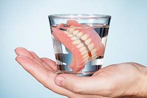 Full set of dentures in a glass of water