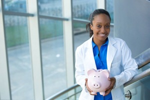 dentist holding a pink piggy bank