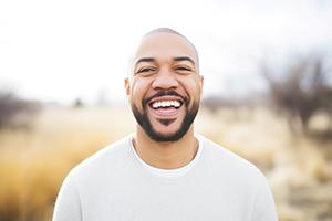 Man in white shirt smiling outside